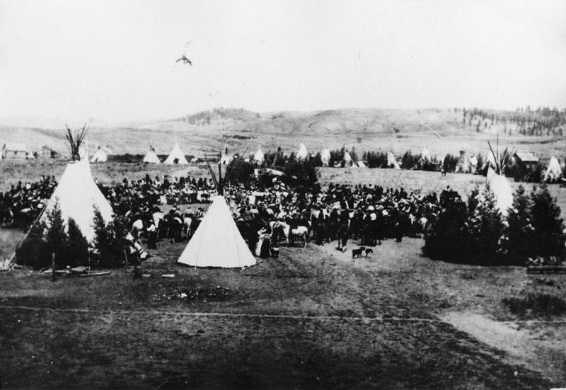 Crowd in camp of tepees